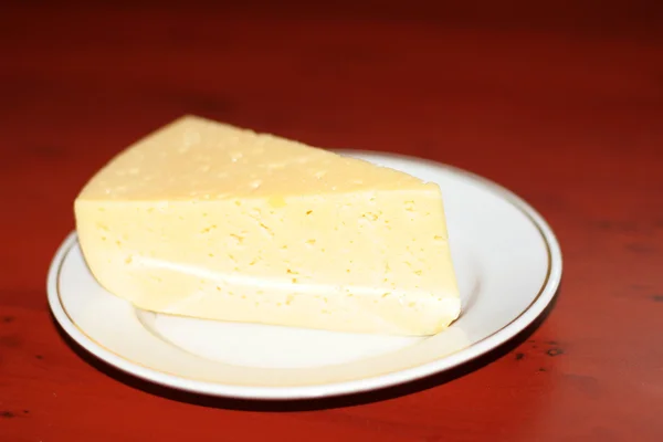 Stück Käse auf leichtem Teller — Stockfoto