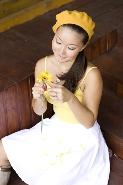 黄色の花を持つ少女のクローズ アップの肖像画 — ストック写真