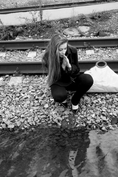Meisje zit in de buurt van rails — Stockfoto