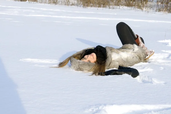 Chica feliz tumbado en la nieve — Stockfoto
