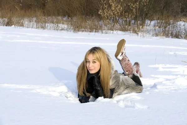 Menina feliz deitado na neve — Fotografia de Stock
