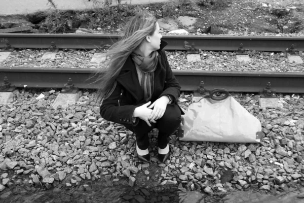Dziewczyna siedzi w pobliżu kolejowe — Zdjęcie stockowe