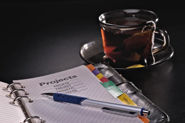 Stift Notizbuch Und Teetasse Vor Dunklem Hintergrund — Stockfoto