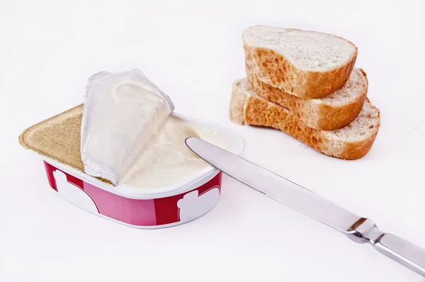 stock image Processed cheese in the plastic dish with a knife and bread slices