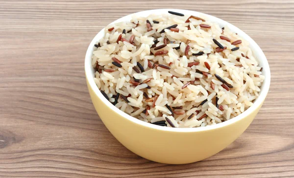 stock image Close up view of cooked variety of rice sorts in yellow bowl - basmati and indian black on wooden background