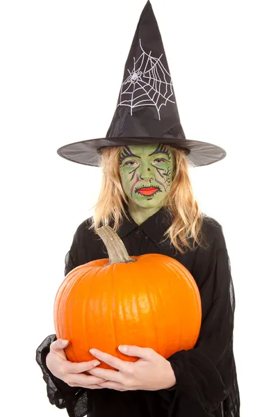 Зеленая ведьма на Хэллоуин держит тыкву — стоковое фото