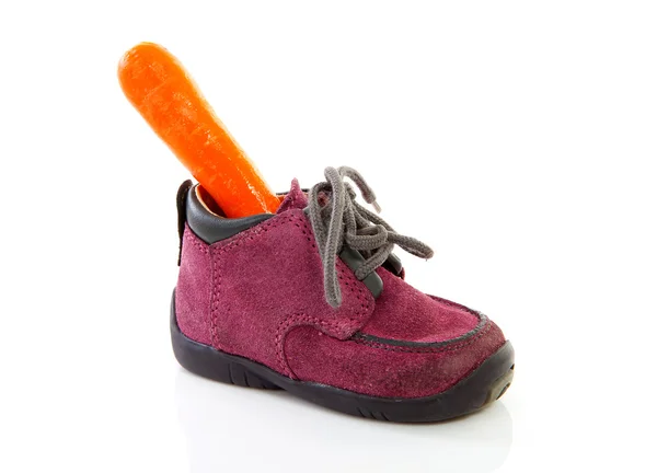 Детская обувь с морковью — стоковое фото