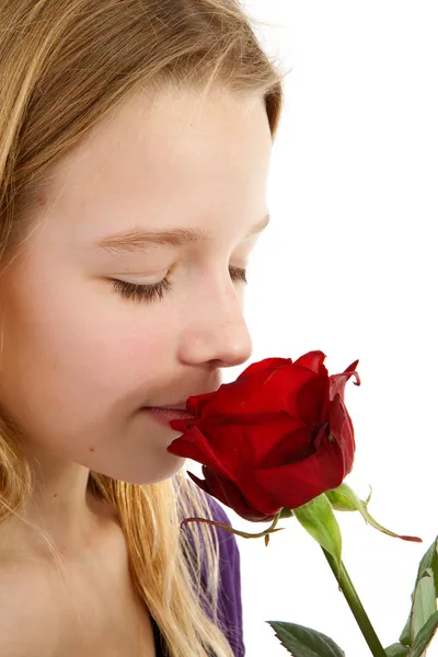 Junges Mädchen, das eine rote Rose riecht — Stockfoto