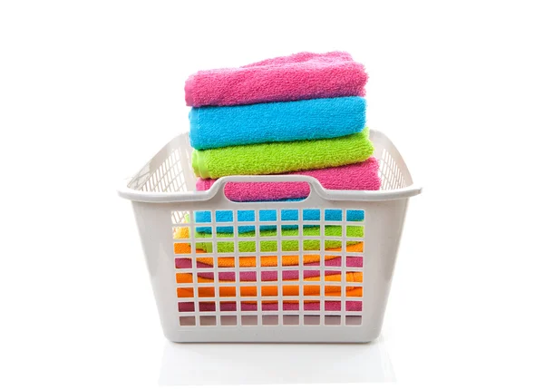 Cesta de lavandaria cheia de toalhas coloridas dobradas — Fotografia de Stock