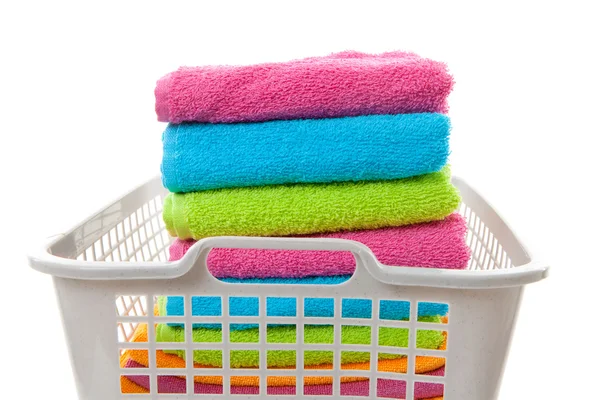 Cesta de lavandaria cheia de toalhas coloridas dobradas — Fotografia de Stock