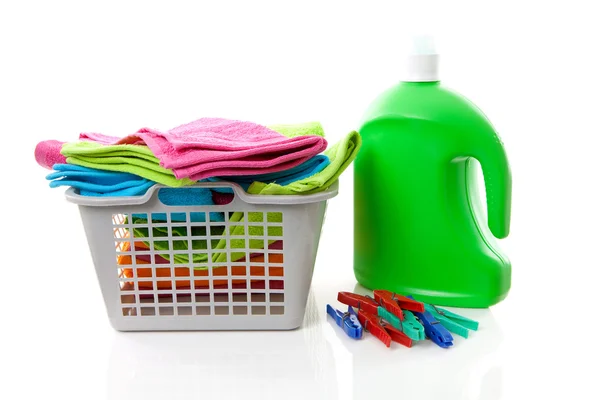 Koš na prádlo plné barevné skládané ručníky, kolíčky a bott — Stock fotografie