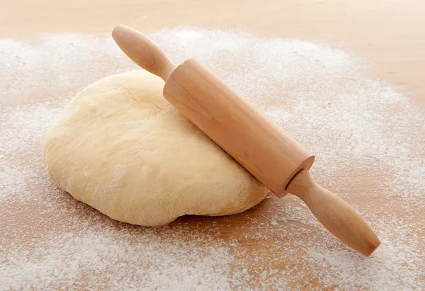 Pizza dough with rolling pin — Stock Photo, Image