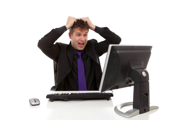Affärsman som sitter bakom skrivbord är i förtvivlan, dra sitt hår — Stockfoto