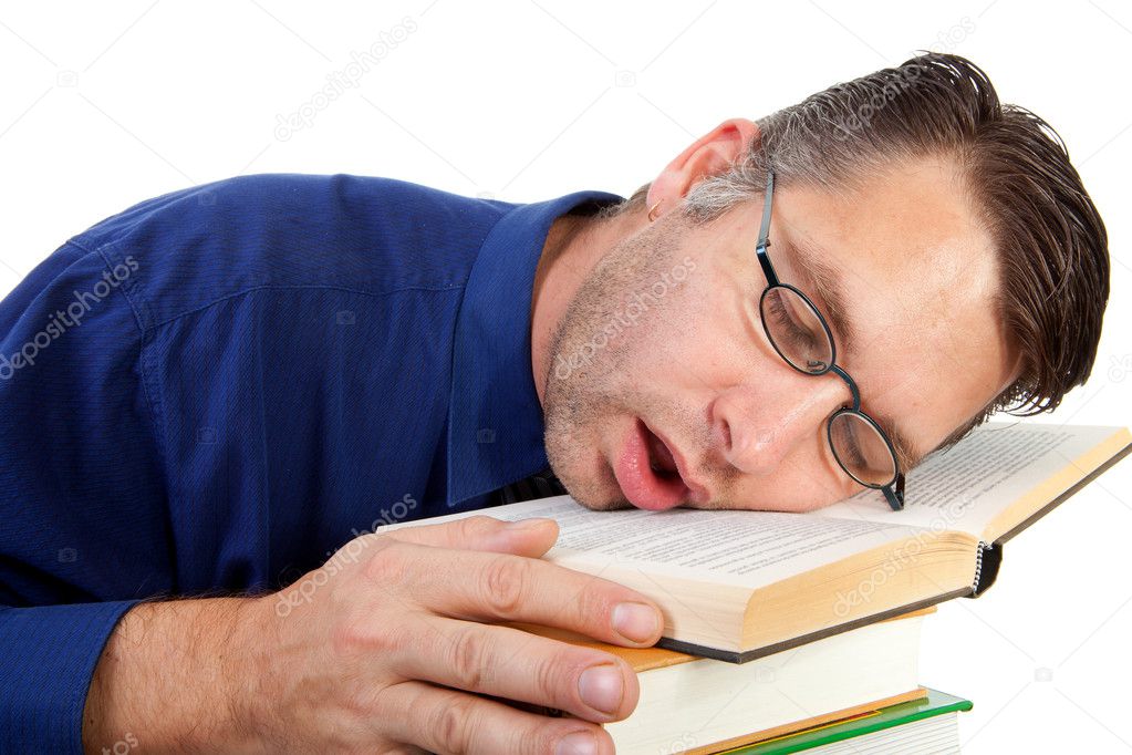 Male nerdy geek fall asleep with face on pile of books