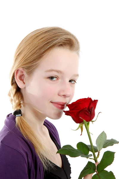 Jovem cheirando uma rosa vermelha em close-up — Fotografia de Stock