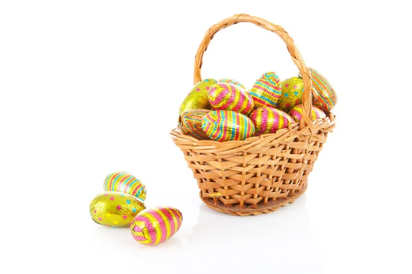 Třtinový koš s barevné velikonoční vajíčka — Stock fotografie