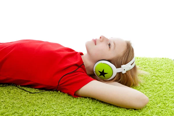 Flickan lyssna på musik med hörlurar på — Stockfoto