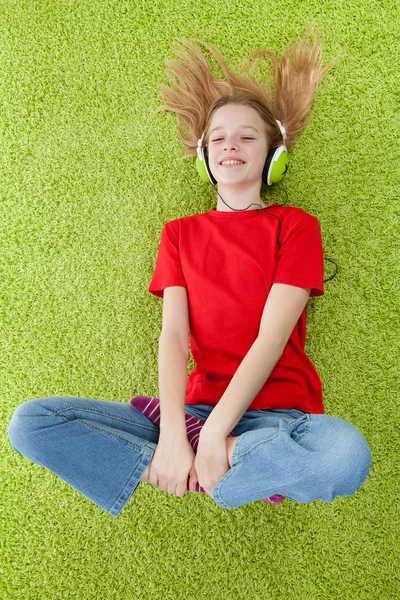 Menina está ouvindo música com fones de ouvido em — Fotografia de Stock