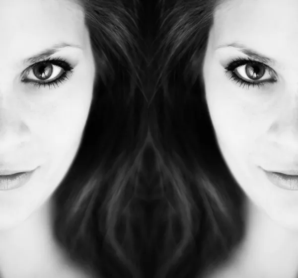 两个镜像的一半的黑色和白色的一个年轻女人脸的意见 — 图库照片