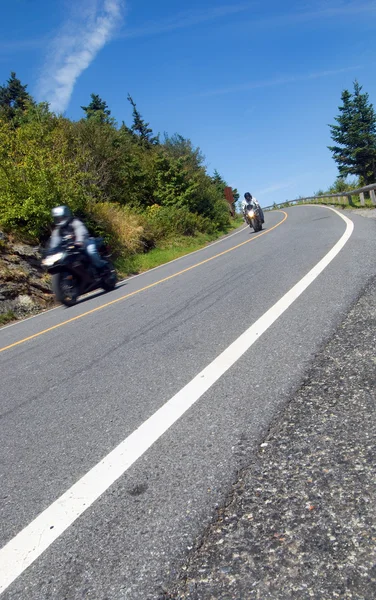 stock image Some speeding motorcyclists riding down a paved mountain road.