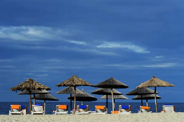 Decks and umbrella on beach — Stock Photo, Image
