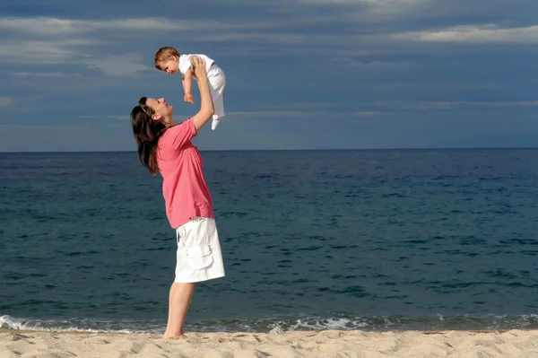 Moeder met haar baby op strand — Stockfoto