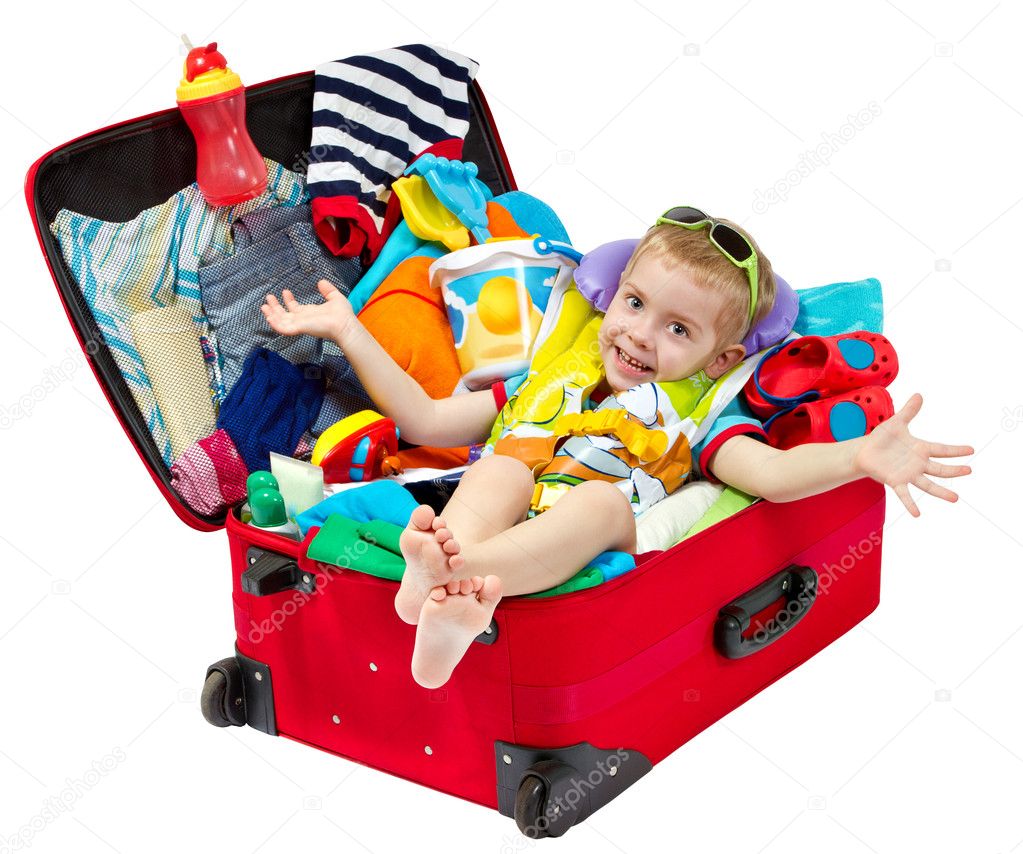 Little kid in travel suitcase packed for vacation