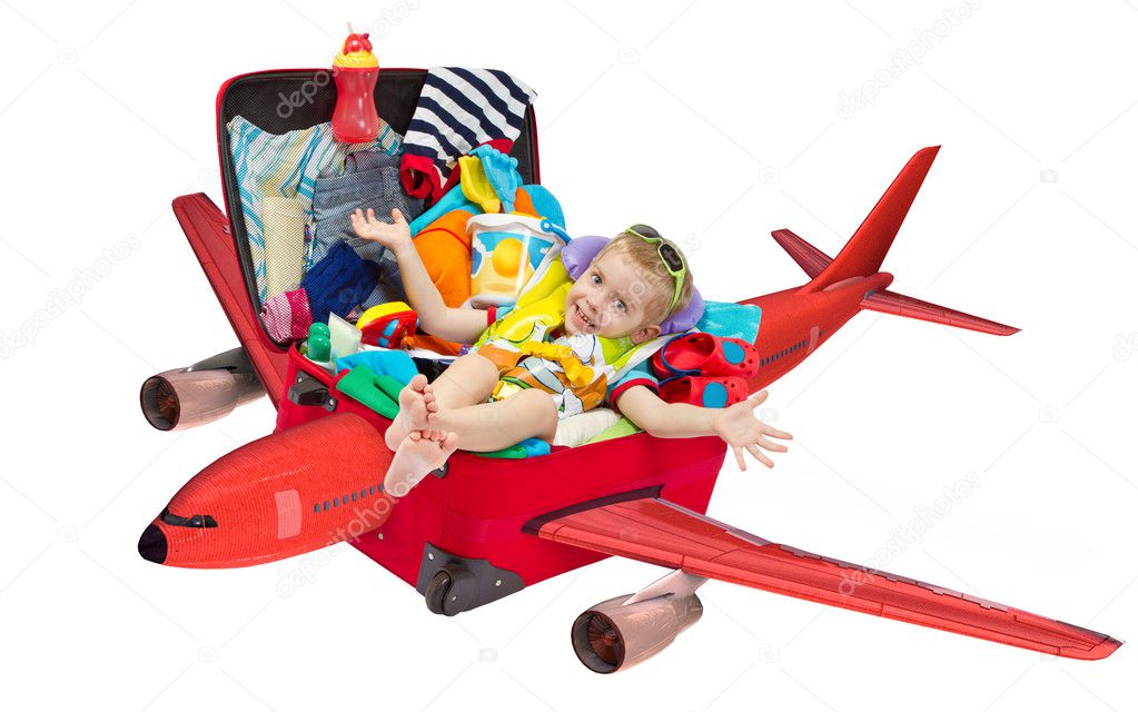 Little kid flying in travel red suitcase. Packed for vacation. Personal belongings. Isolated on white