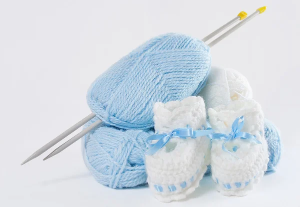Gebreide handgemaakte baby's bootees, bal van garen, naalden — Stockfoto
