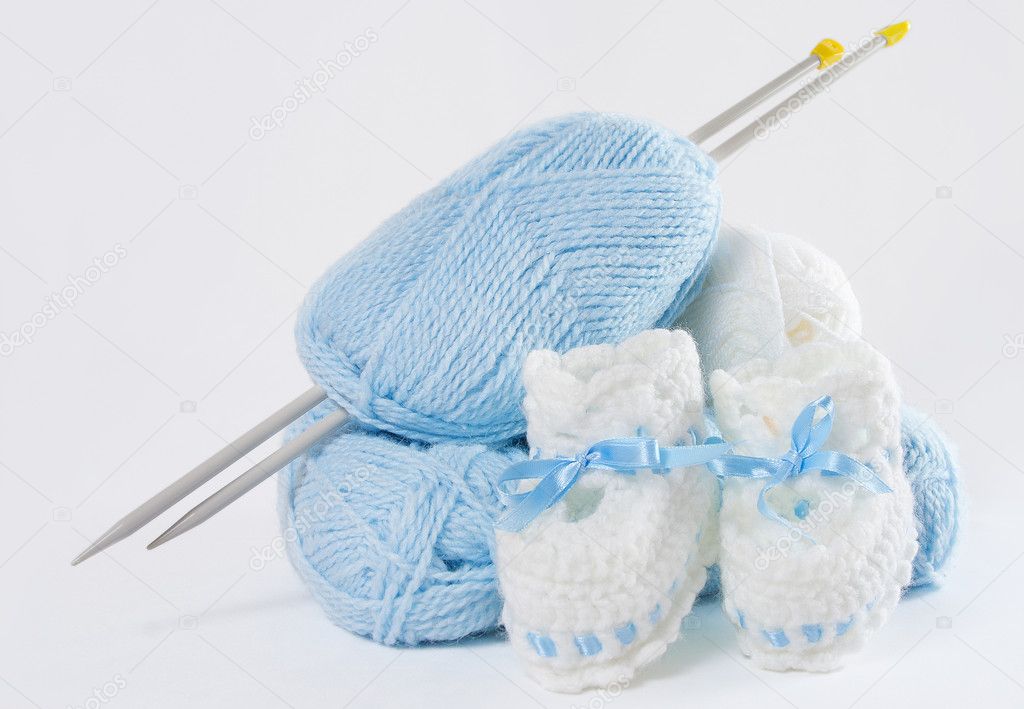 Knitted handmade baby's bootees, ball of yarn, needles