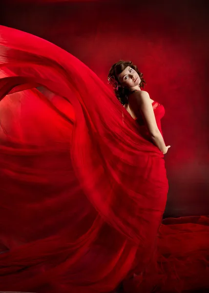 Beautiful woman in red flying waving dress. Royalty Free Stock Photos