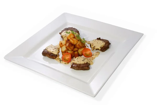 stock image Sirloin steak with sauted potatoes and fresh cherry tomatoes on a white plate.