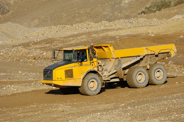 一辆黄色的自卸卡车驾驶在矿井 — 图库照片
