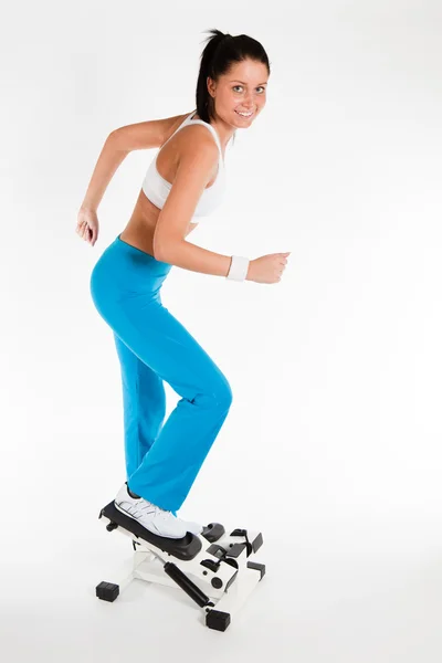 Mujer haciendo ejercicio en stepper trainer — Foto de Stock