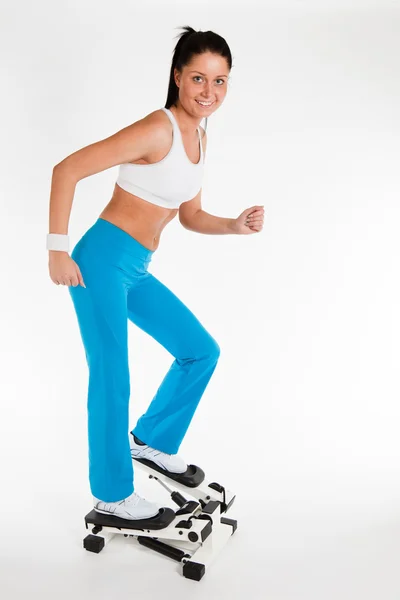 Woman working out on stepper trainer — Stock Photo, Image