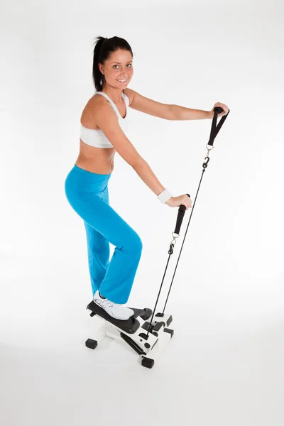 Mujer haciendo ejercicio en stepper trainer — Foto de Stock