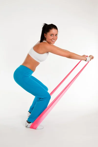 Mulher exercitando com fita de borracha — Fotografia de Stock