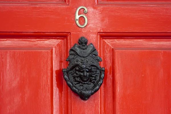 Uma porta de madeira vermelha com um grande batedor de porta georgiano — Fotografia de Stock