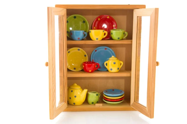 Cupboard with cheerful crockery — Stock Photo, Image