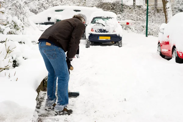Человек убирает снег — стоковое фото