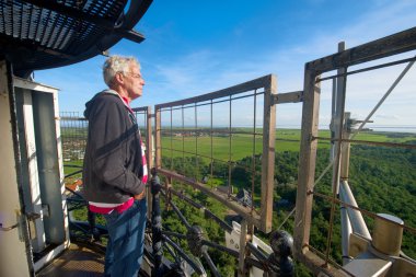 Man at lighthouse looking to the landscape clipart