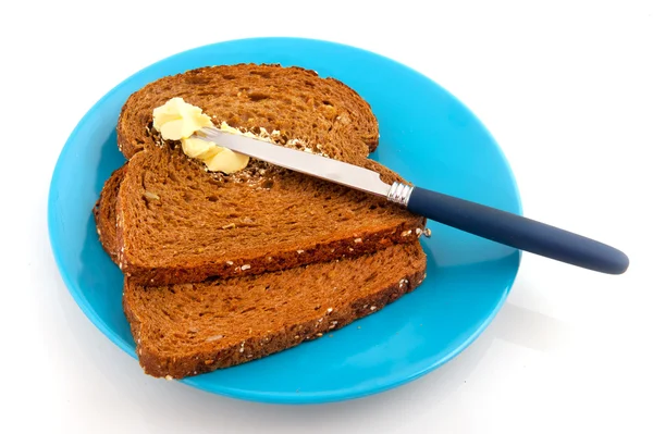 Twee Sneetjes Bruin Brood Met Boter Blauw Bord — Stockfoto
