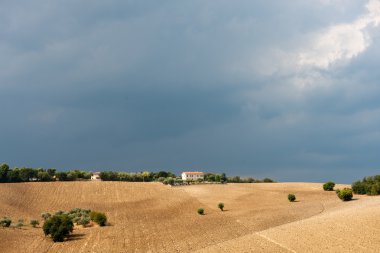 karanlık gökyüzü tepe üzerinde bir ev ile bir İtalyan Peyzaj arkasında