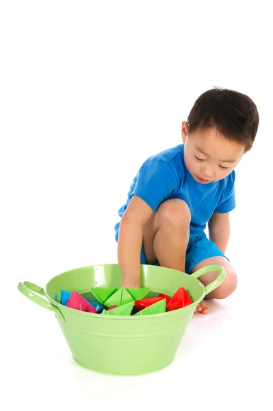 Chinese boy playing with paper boats — Stock Photo, Image