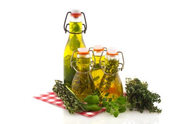 Olive oil with verious kinds of fresh herbs isolated over white clipart