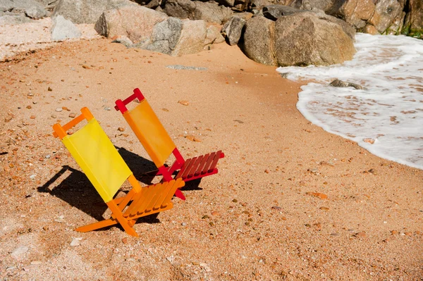 Tomme, fargerike stoler på stranden – stockfoto