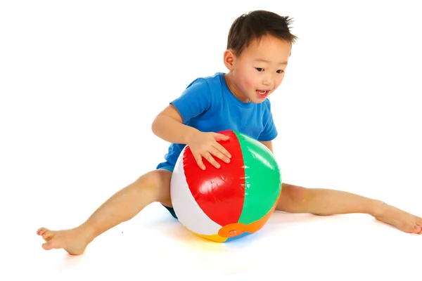 Китайский мальчик играет с пляжным мячом — стоковое фото