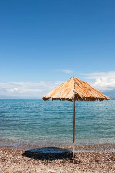 希腊海滩与秸秆阳伞 — 图库照片