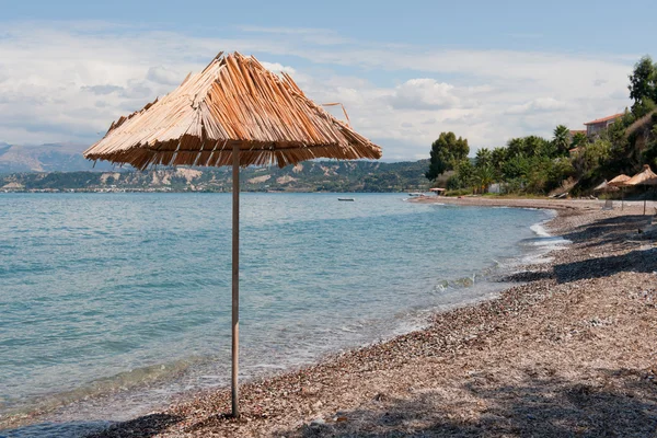 Греческий пляж с пустой скамейкой — стоковое фото