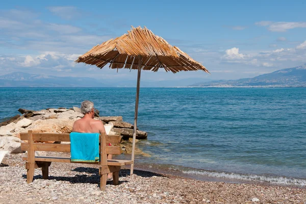 Греческий пляж с мужчиной — стоковое фото